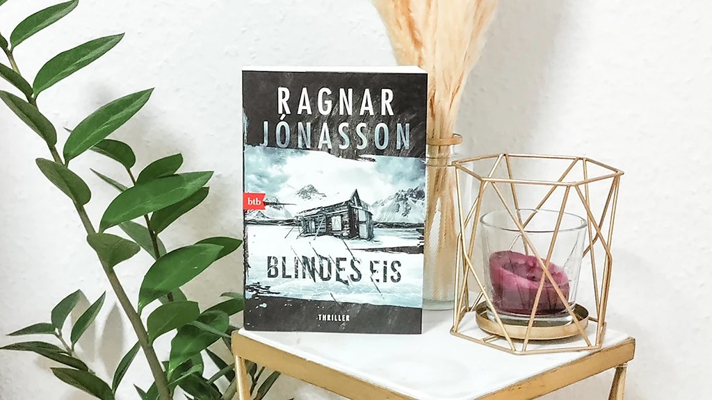 Foto des Buchs Ragnar Jónasson: Blindes Eis mit Kerze und Pflanze auf einem Beistelltisch